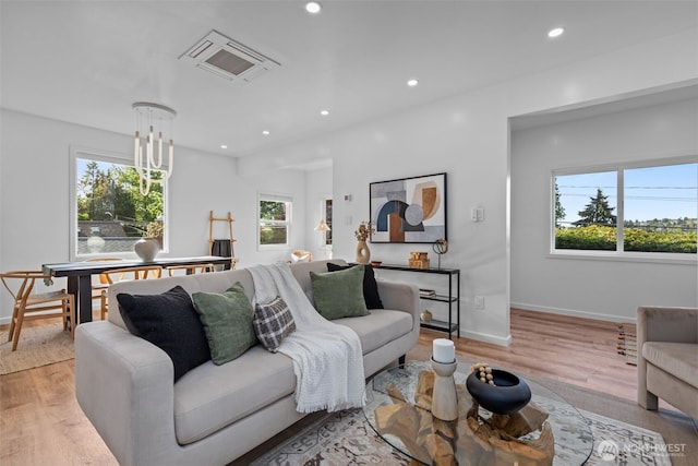 living room featuring recessed lighting, baseboards, visible vents, and light wood finished floors
