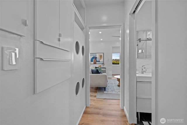 hall with a sink and light wood-style flooring