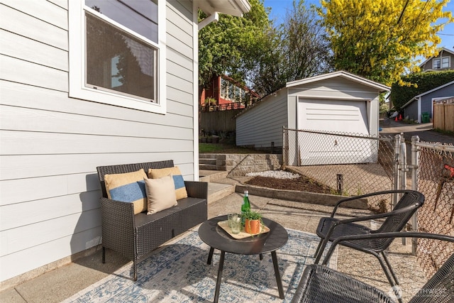 view of patio / terrace with an outdoor structure, fence, and an outdoor hangout area