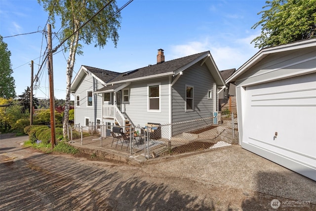 ranch-style home featuring fence, a chimney, and roof with shingles