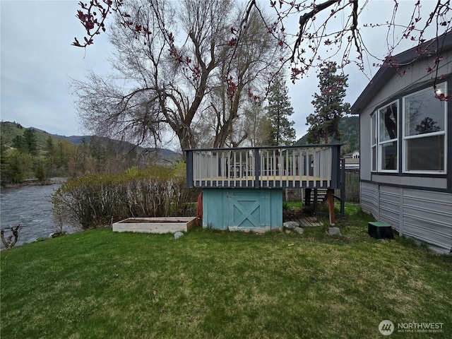 view of yard featuring a shed, an outdoor structure, and a water view