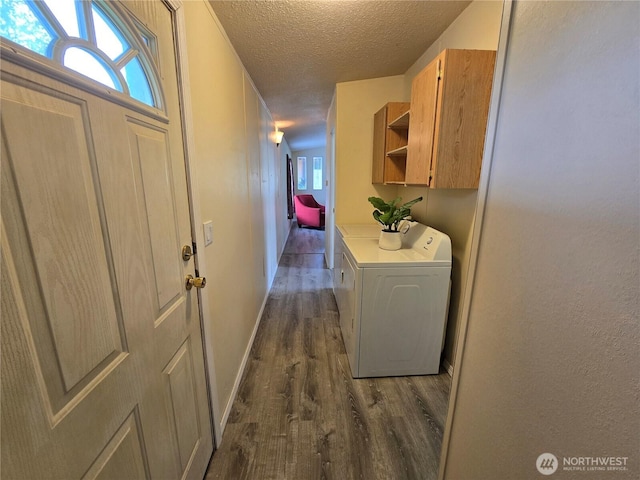 hall featuring dark wood-type flooring, a textured ceiling, separate washer and dryer, and plenty of natural light