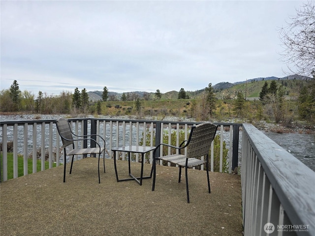 balcony featuring a water and mountain view