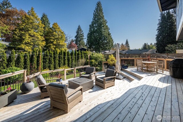 wooden terrace with an outdoor hangout area and outdoor dining space