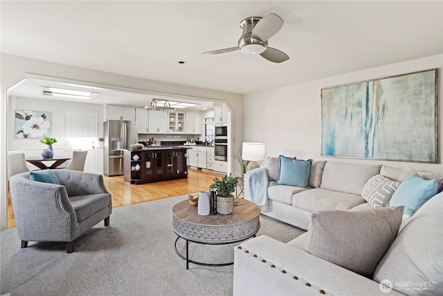 living area with a ceiling fan and light wood-style flooring