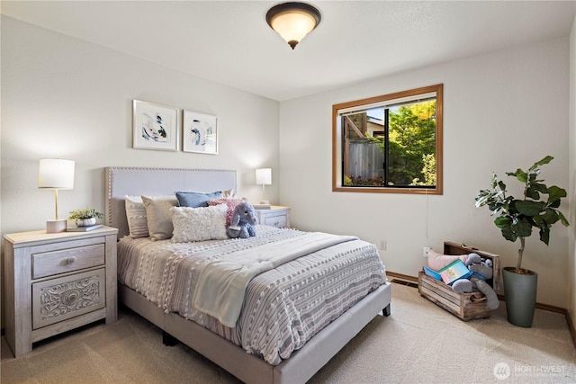 bedroom with baseboards and light colored carpet