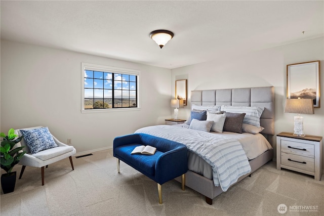 bedroom with baseboards, light carpet, and visible vents