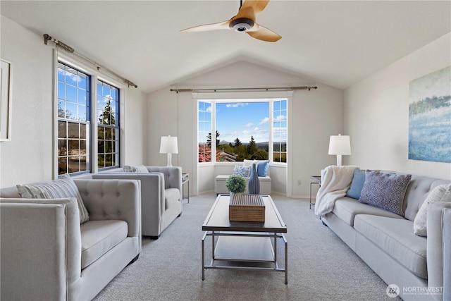 carpeted living area with ceiling fan, baseboards, and lofted ceiling