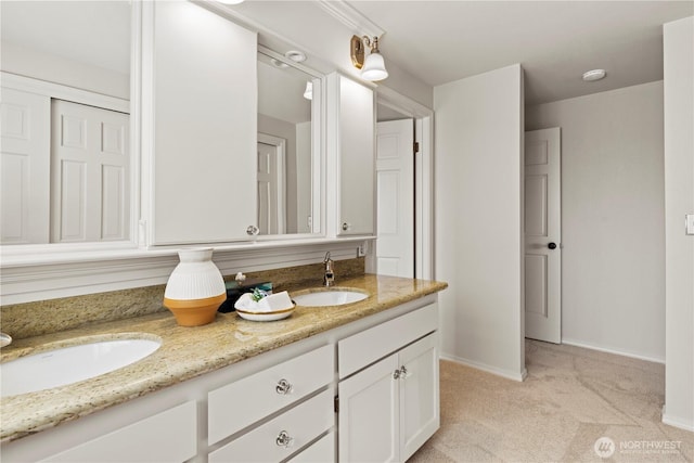 full bath with a sink, baseboards, and double vanity