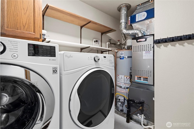 clothes washing area featuring separate washer and dryer, cabinet space, and water heater
