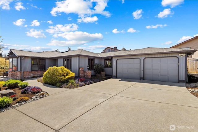 single story home featuring concrete driveway, brick siding, and a garage