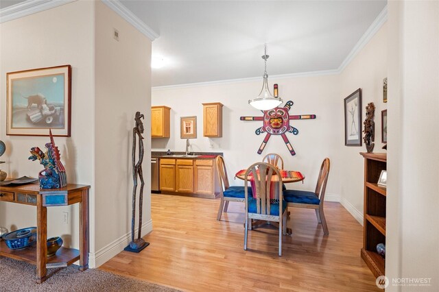 dining room featuring crown molding, baseboards, and light wood-type flooring