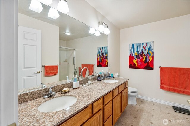 bathroom featuring a sink, a skylight, a stall shower, and double vanity
