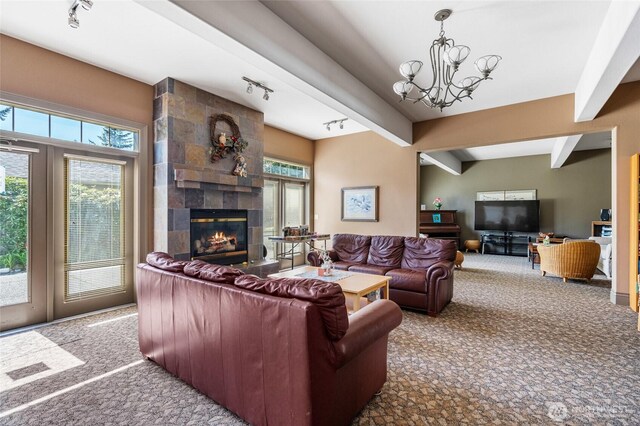 carpeted living room with a tiled fireplace, a notable chandelier, beam ceiling, and a healthy amount of sunlight