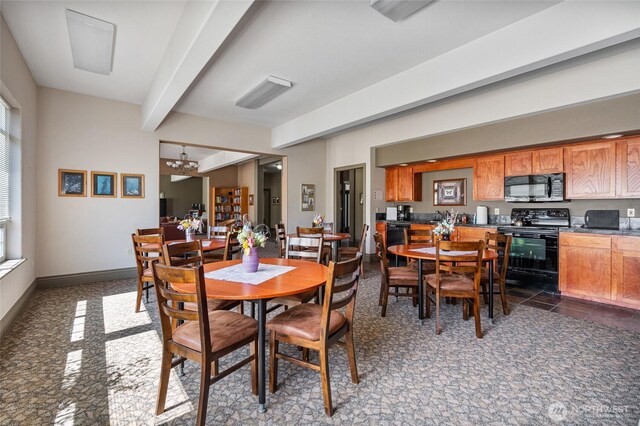 dining area with baseboards, an inviting chandelier, and beam ceiling