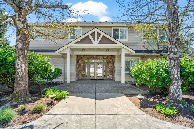 traditional home featuring french doors and stone siding