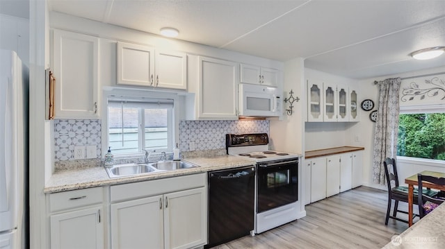 kitchen with white microwave, black dishwasher, electric range oven, a sink, and white cabinets