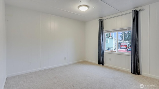 carpeted spare room featuring baseboards