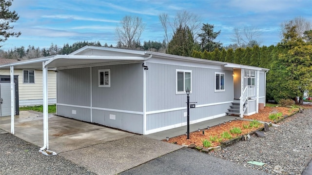 view of side of home featuring a carport and concrete driveway