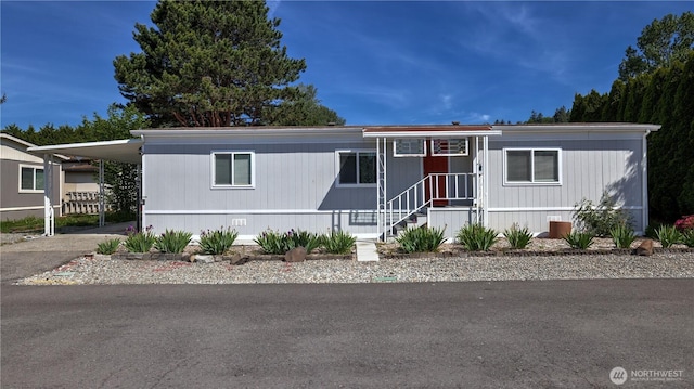 manufactured / mobile home featuring a carport and asphalt driveway