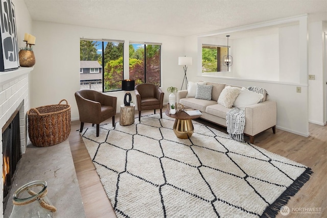 living room with wood finished floors, a fireplace, and baseboards