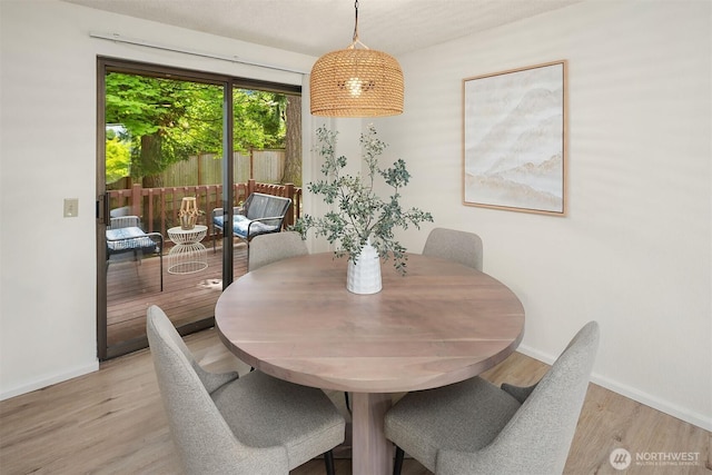 dining area featuring baseboards and light wood-style floors
