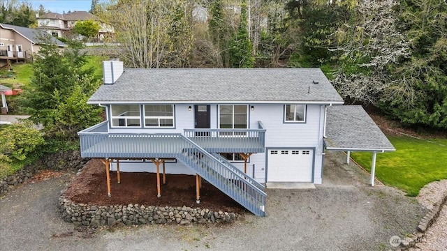 9360 SE Southworth Dr, Port Orchard, WA 98366 - view of front of property with a garage, stairway, a chimney, a shingled roof, and driveway