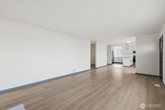 9360 SE Southworth Dr, Port Orchard, WA 98366 - unfurnished living room featuring light wood finished floors, baseboards, and visible vents