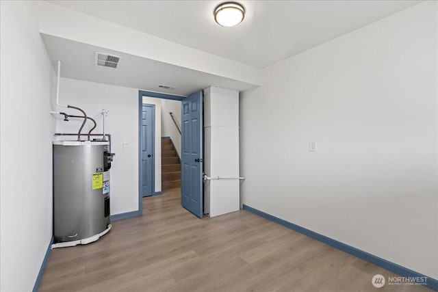 9360 SE Southworth Dr, Port Orchard, WA 98366 - finished below grade area featuring visible vents, baseboards, electric water heater, light wood finished floors, and stairs