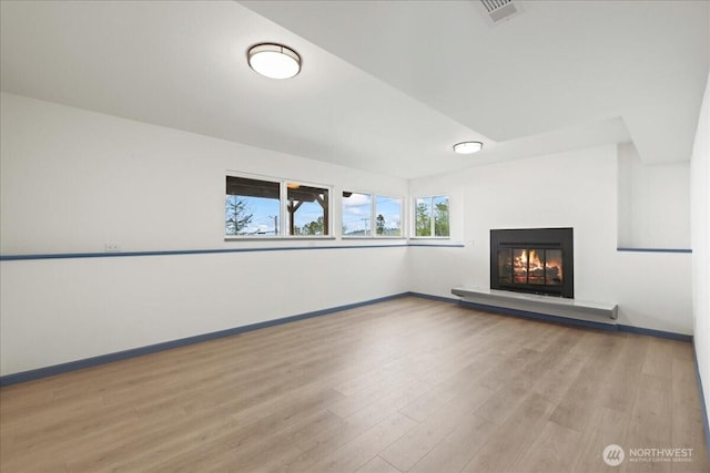 9360 SE Southworth Dr, Port Orchard, WA 98366 - unfurnished living room featuring a glass covered fireplace, visible vents, baseboards, and wood finished floors