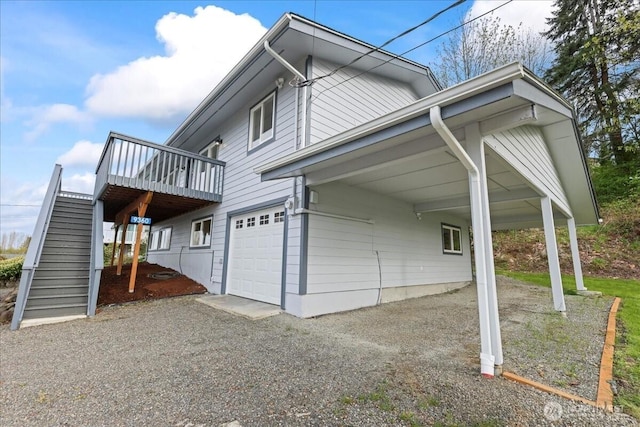 9360 SE Southworth Dr, Port Orchard, WA 98366 - view of property exterior featuring stairway, a carport, gravel driveway, a garage, and a deck