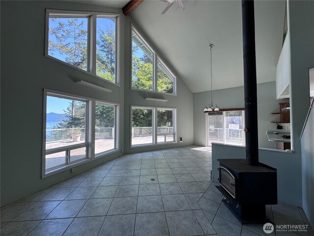 218 Pass View Rd, Decatur Island, WA 98221 - unfurnished living room featuring high vaulted ceiling, healthy amount of natural light, a wood stove, tile patterned flooring, and beam ceiling