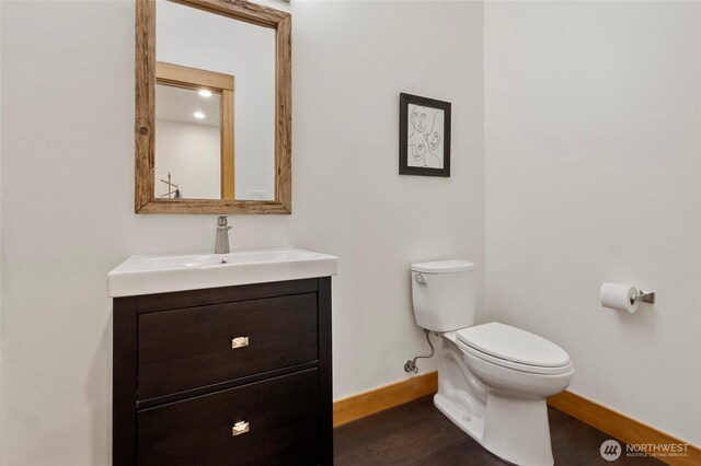 8996 Dearborn Ave, Blaine, WA 98230 - half bathroom featuring baseboards, vanity, toilet, and wood finished floors