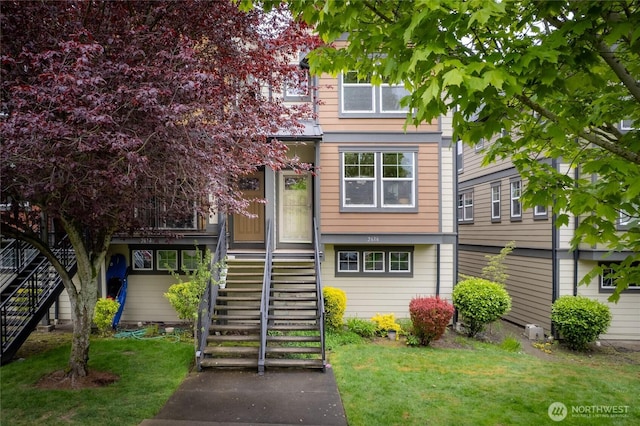 view of front of house featuring stairs and a front lawn