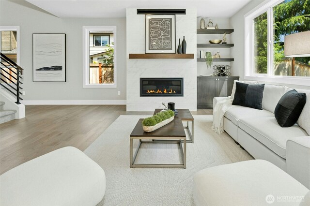 10284 133rd Ct NE, Redmond, WA 98033 - living area featuring wood finished floors, stairs, a glass covered fireplace, and baseboards