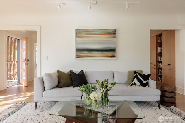 living area with track lighting and wood finished floors