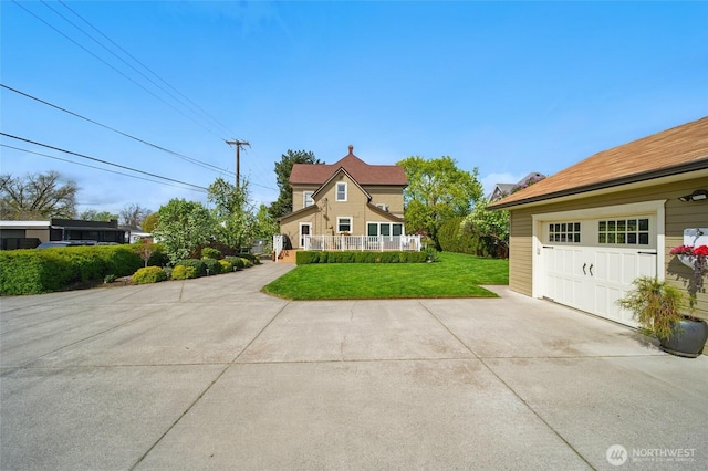 view of side of property featuring a garage, a yard, and driveway