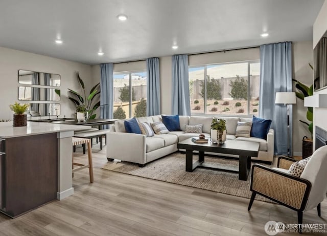 living area featuring light wood-style flooring and recessed lighting