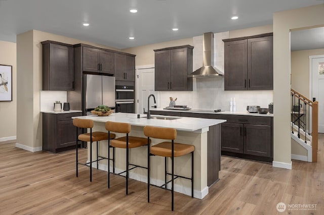 450 185th Street Ct E Unit 22, Spanaway, WA 98387 - kitchen with a sink, multiple ovens, dark brown cabinetry, wall chimney range hood, and baseboards