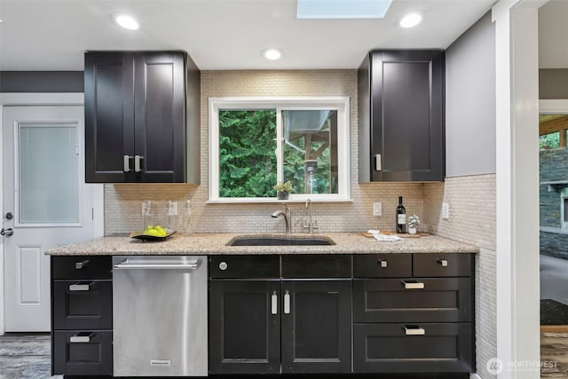 320 SW Forest Dr, Issaquah, WA 98027 - kitchen with stainless steel dishwasher, a sink, decorative backsplash, and light stone countertops