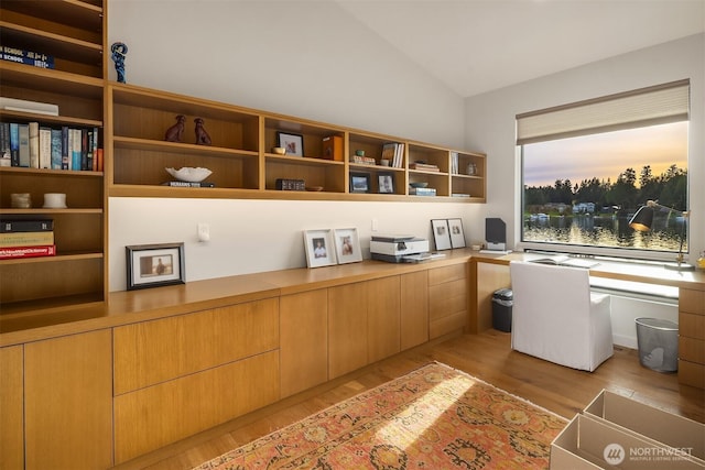 office featuring built in study area, lofted ceiling, and light wood-style floors