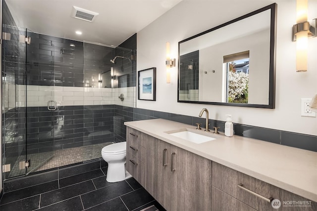 full bath with toilet, vanity, visible vents, tile patterned floors, and a stall shower