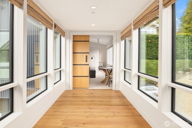 unfurnished sunroom featuring recessed lighting and wood finished floors