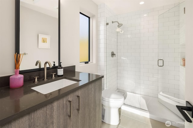 bathroom featuring vanity, toilet, a shower stall, and tile patterned flooring