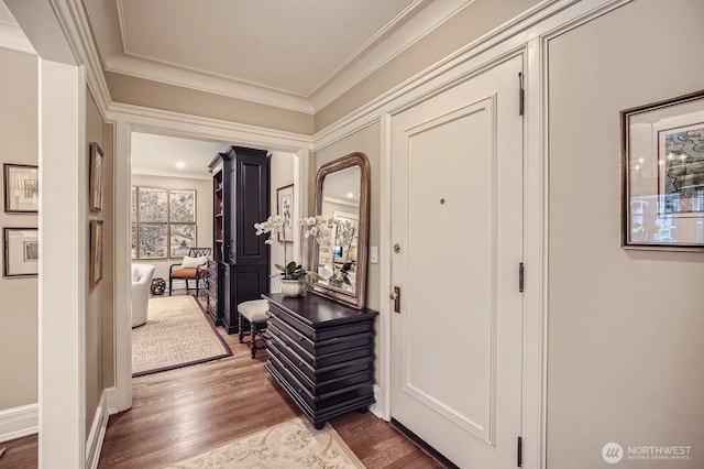 entrance foyer with arched walkways, crown molding, and wood finished floors