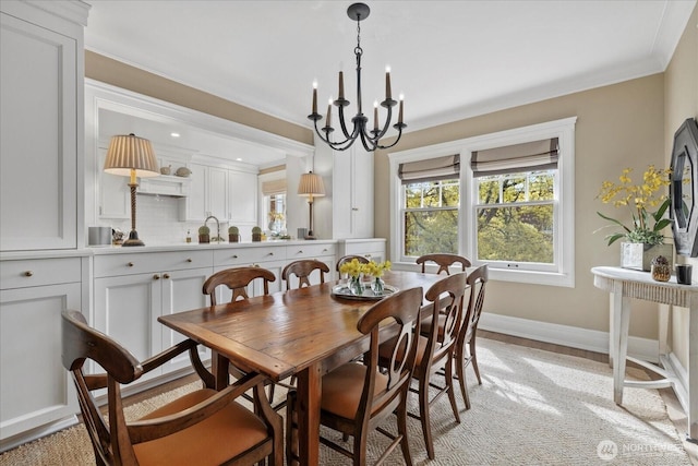 dining area with a chandelier, crown molding, and baseboards