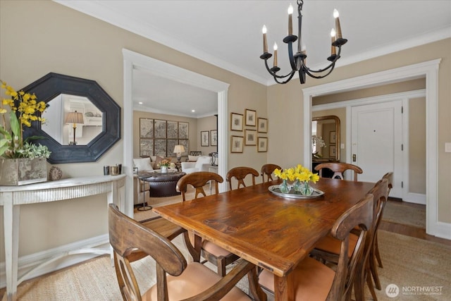 dining space featuring light wood-style flooring, baseboards, a notable chandelier, and ornamental molding