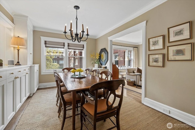 dining space featuring ornamental molding, baseboards, a notable chandelier, and a healthy amount of sunlight