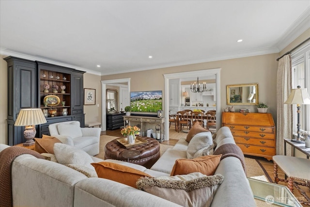 living room featuring an inviting chandelier, ornamental molding, and light wood finished floors