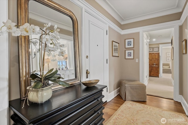 interior space featuring wood finished floors, crown molding, and baseboards